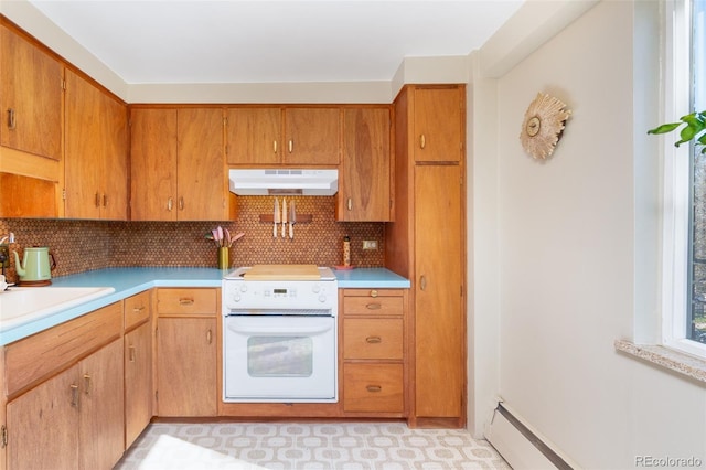 kitchen featuring stove, light countertops, under cabinet range hood, tasteful backsplash, and a sink