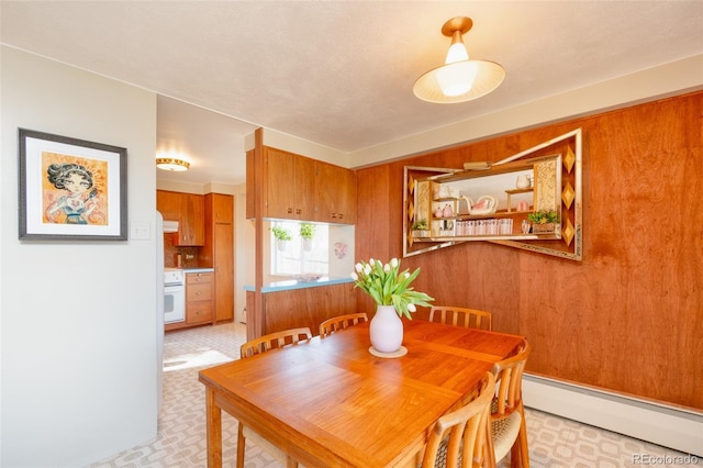dining space featuring baseboard heating and light floors