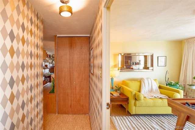 hall featuring carpet floors and wallpapered walls