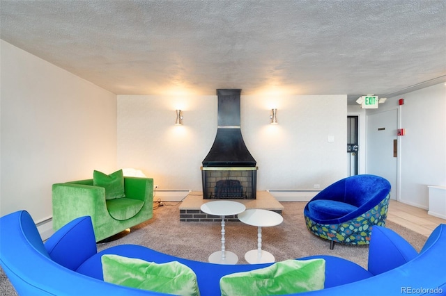 living room featuring baseboards, carpet flooring, a textured ceiling, and a baseboard heating unit