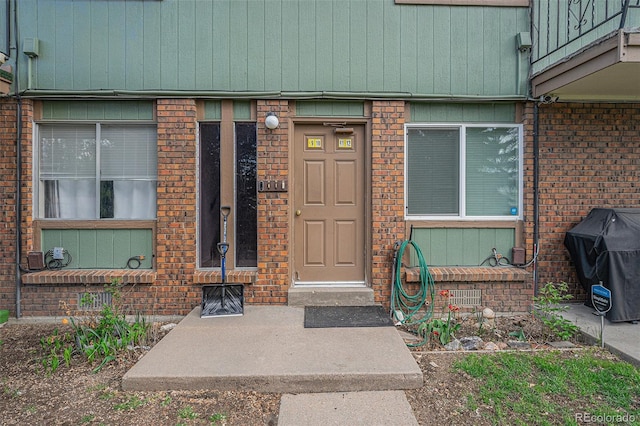 doorway to property with brick siding