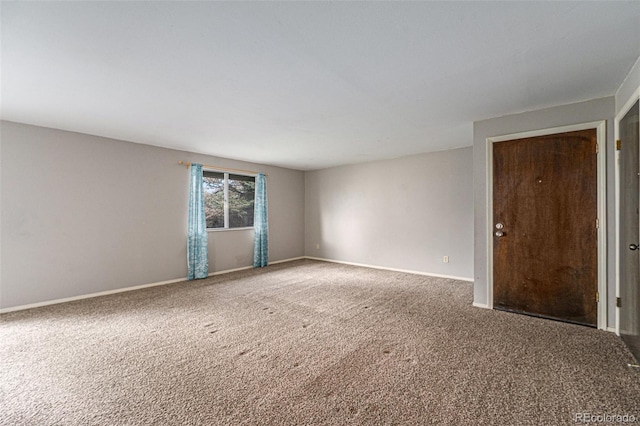 spare room featuring baseboards and carpet