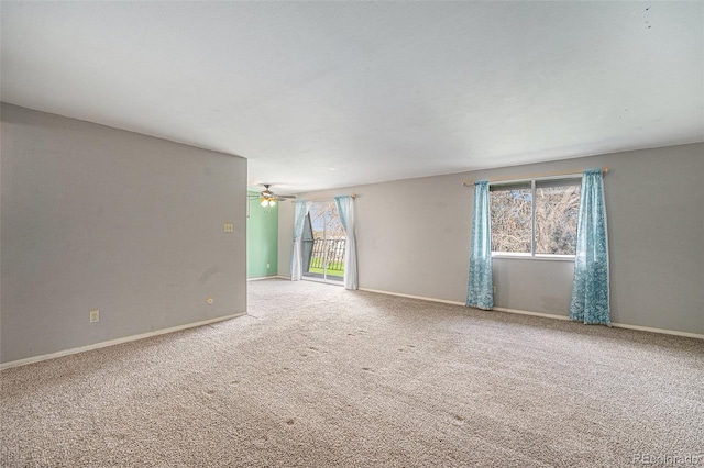 carpeted spare room with baseboards, plenty of natural light, and ceiling fan