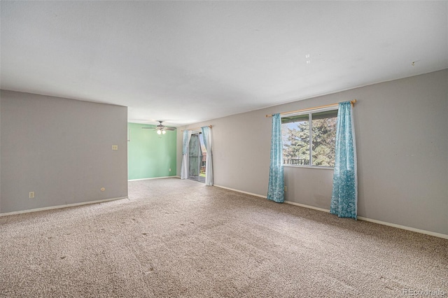 carpeted empty room with baseboards and a ceiling fan