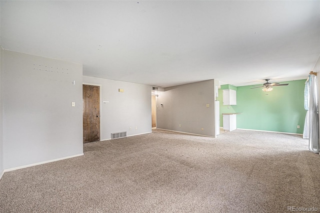unfurnished living room with visible vents, carpet flooring, baseboards, and ceiling fan
