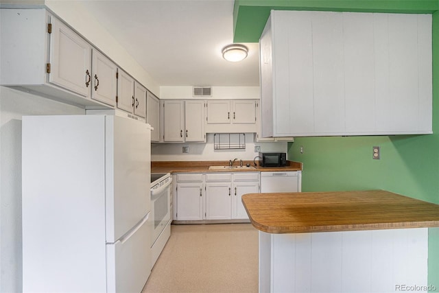 kitchen with visible vents, a sink, white cabinetry, and white appliances