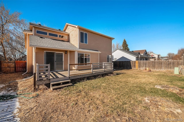 rear view of property featuring a lawn and a wooden deck