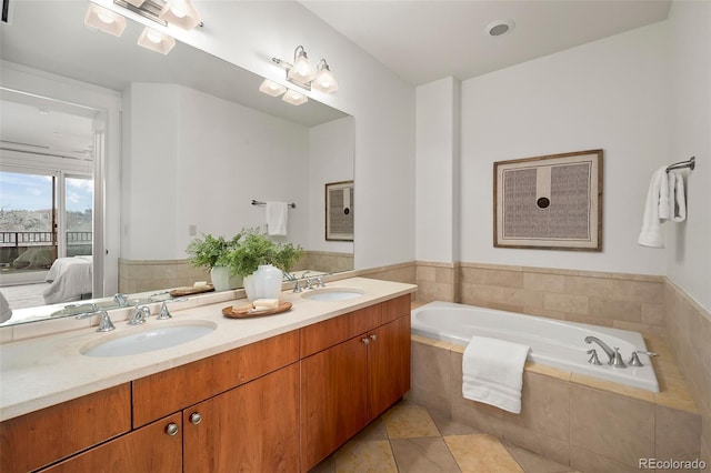 full bathroom featuring double vanity, a garden tub, a sink, and ensuite bathroom