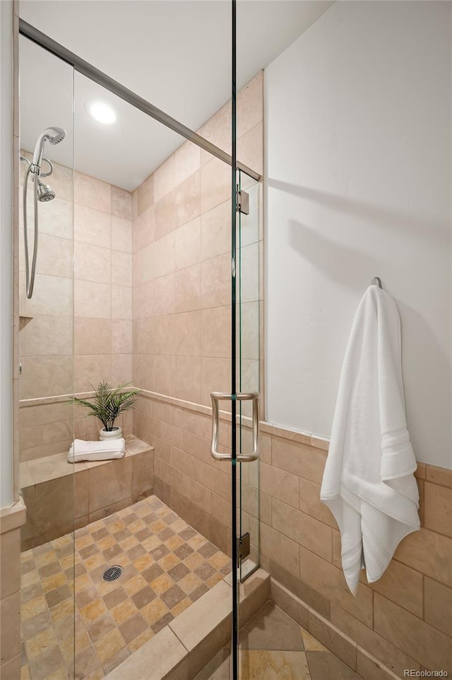 full bath featuring a stall shower and tile walls