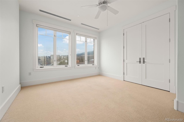 unfurnished bedroom featuring carpet, a closet, visible vents, a ceiling fan, and baseboards