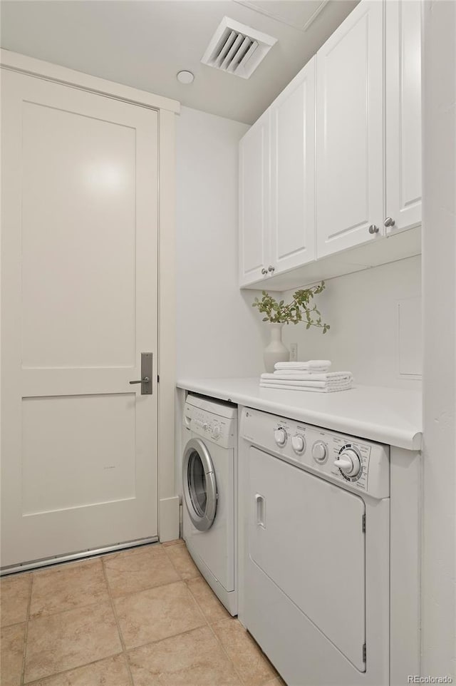 laundry room with cabinet space, light tile patterned floors, visible vents, and washer and dryer