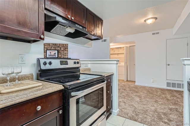 kitchen with visible vents, light carpet, dark brown cabinets, stainless steel range with electric stovetop, and under cabinet range hood