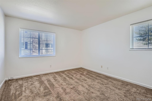 empty room with baseboards and carpet flooring