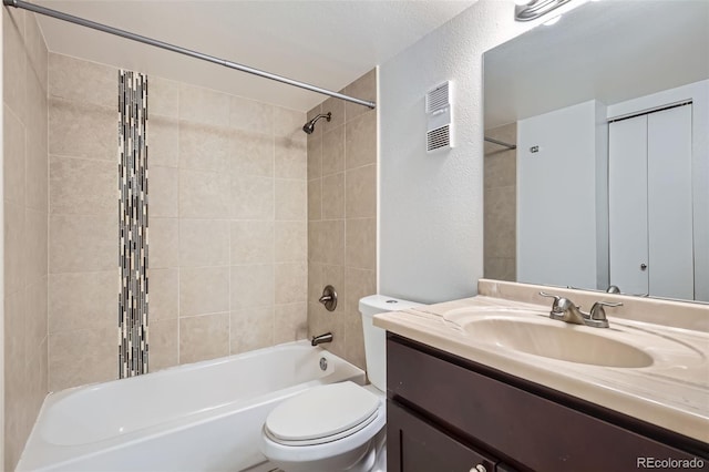 bathroom with visible vents, a textured wall, toilet, washtub / shower combination, and vanity