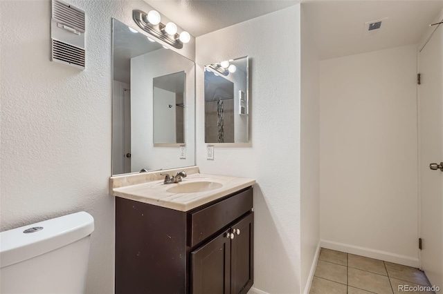 bathroom with baseboards, visible vents, toilet, tile patterned floors, and vanity