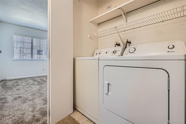 laundry room featuring light carpet, a textured ceiling, baseboards, and separate washer and dryer