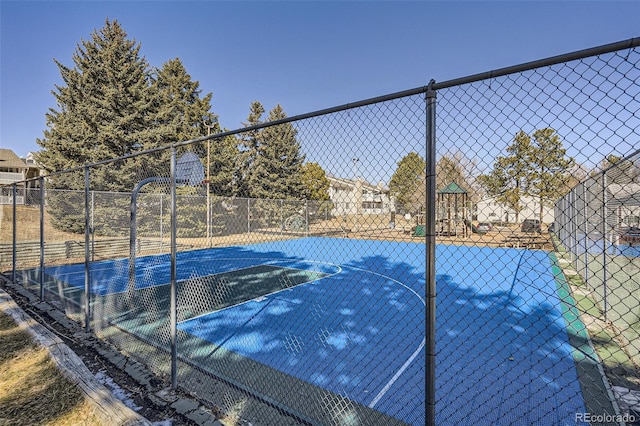 view of sport court featuring community basketball court, playground community, and fence