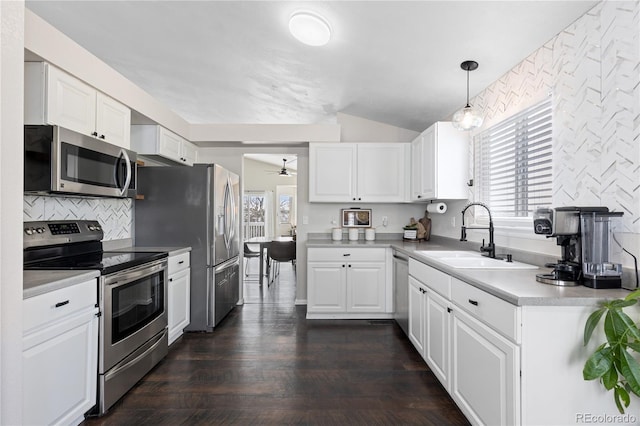 kitchen with stainless steel appliances, a sink, white cabinetry, and a healthy amount of sunlight