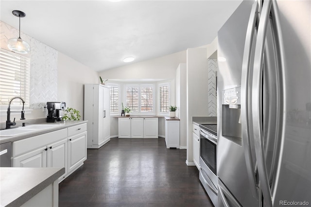 kitchen featuring dark wood finished floors, lofted ceiling, stainless steel appliances, white cabinetry, and a sink