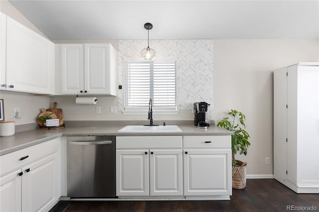 kitchen with light countertops, stainless steel dishwasher, a sink, and white cabinetry