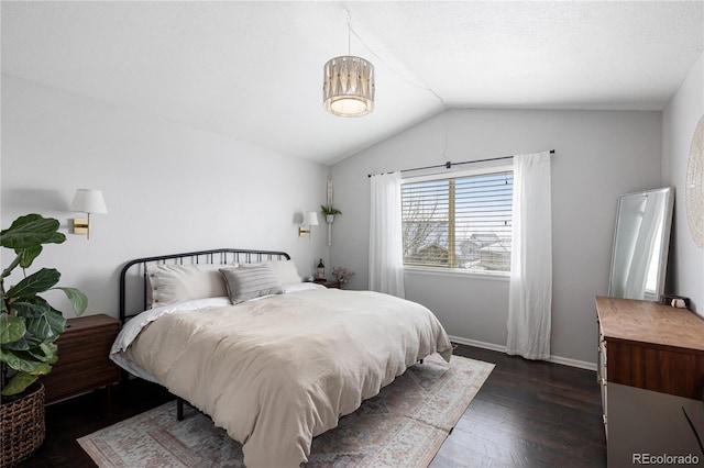 bedroom featuring lofted ceiling, baseboards, and dark wood-style flooring