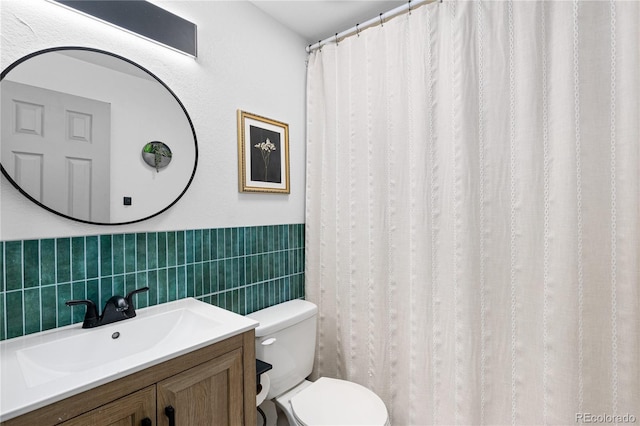 full bathroom with vanity, toilet, and tile walls