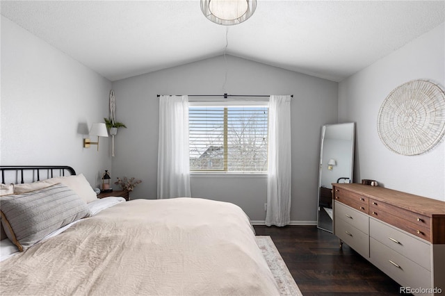 bedroom with vaulted ceiling, dark wood-style flooring, and baseboards