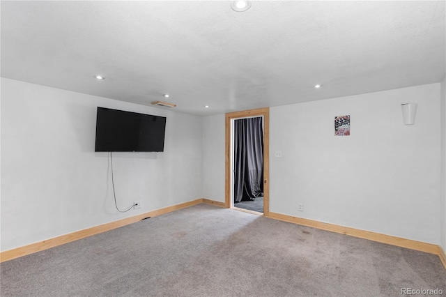 carpeted spare room with recessed lighting, a textured ceiling, and baseboards