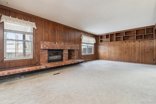 unfurnished living room featuring a fireplace, a textured ceiling, and carpet floors