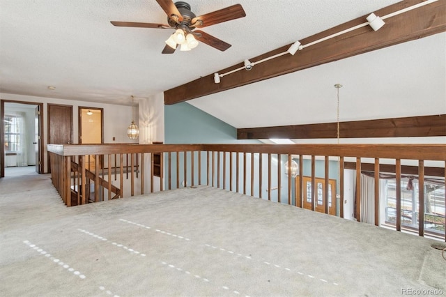 hallway featuring light carpet, lofted ceiling with beams, and a textured ceiling