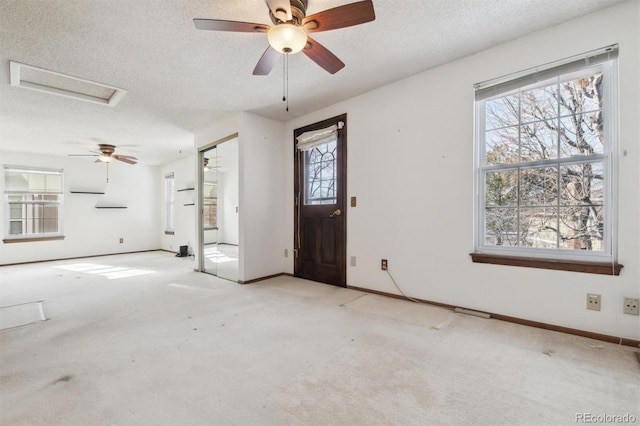 carpeted entrance foyer with a textured ceiling and ceiling fan