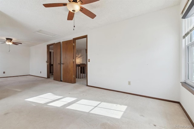 empty room with ceiling fan, light carpet, plenty of natural light, and a textured ceiling