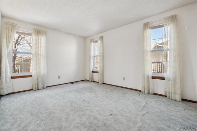 spare room featuring a textured ceiling and carpet