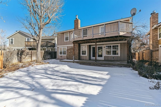 snow covered rear of property featuring a deck