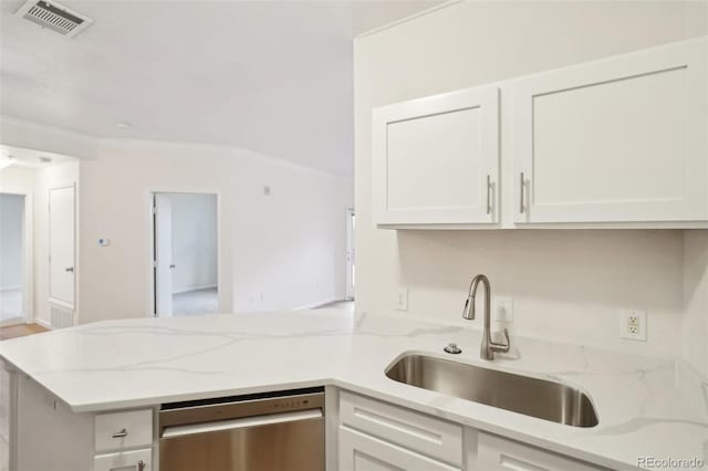 kitchen featuring visible vents, stainless steel dishwasher, a sink, a peninsula, and white cabinetry