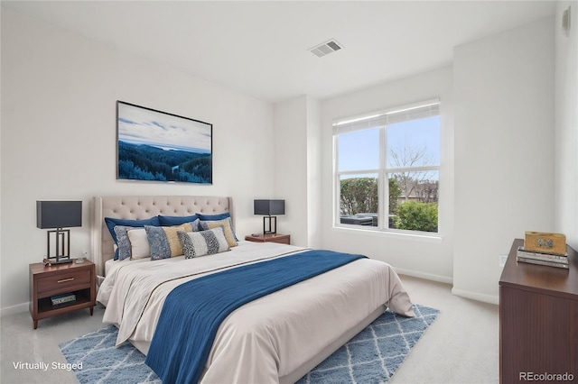 bedroom with baseboards, visible vents, and light carpet