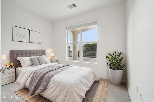 bedroom featuring baseboards, visible vents, and light carpet