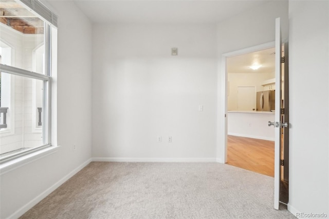 carpeted empty room with baseboards