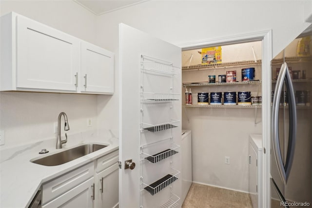 interior space featuring independent washer and dryer, a sink, and cabinet space