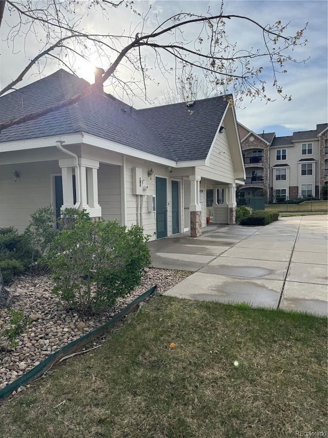 view of property exterior featuring a patio and a shingled roof