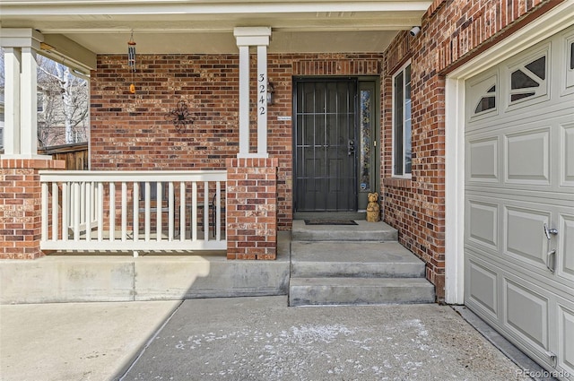 property entrance with a garage and brick siding