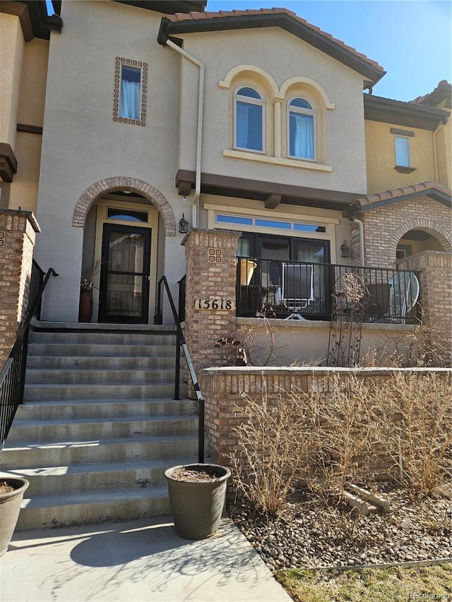 exterior space with a tile roof and stucco siding