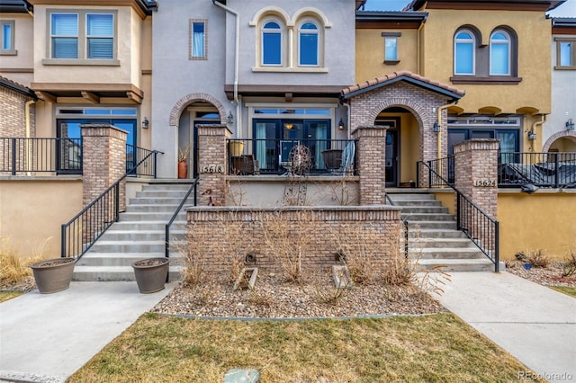 view of front of home with stairs and stucco siding