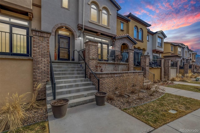 view of front of house featuring stairs, a residential view, and stucco siding