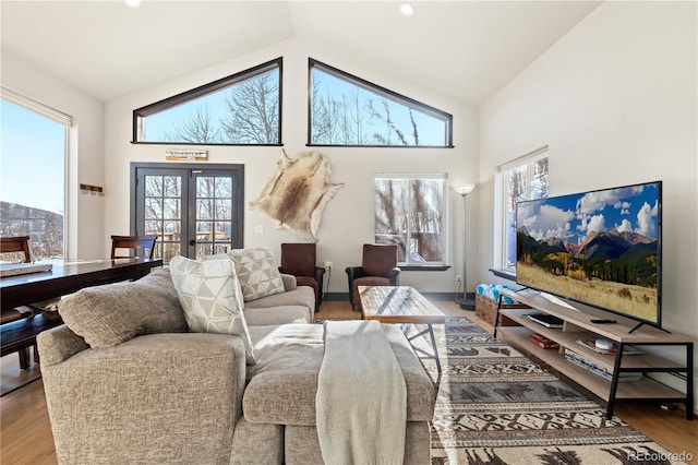 living room with french doors, high vaulted ceiling, and hardwood / wood-style flooring