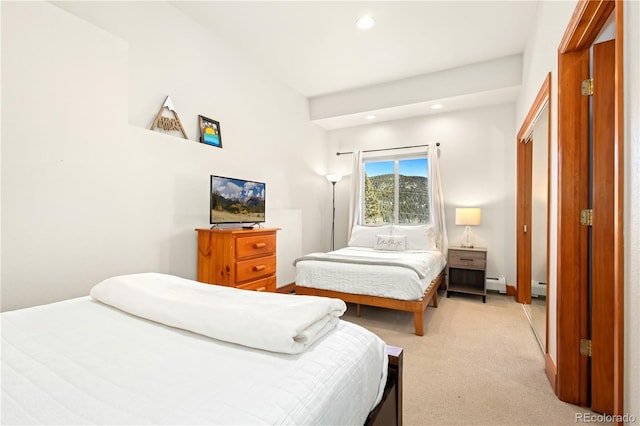 bedroom featuring a baseboard heating unit and light colored carpet