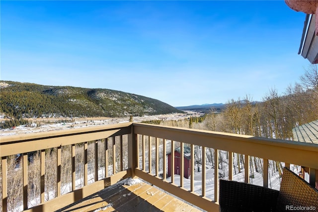 snow covered deck with a mountain view