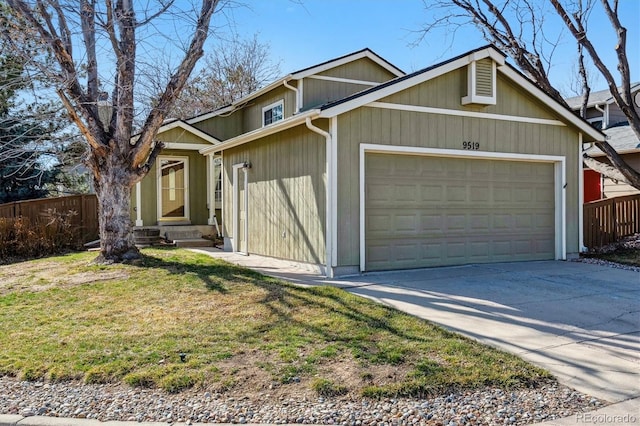 view of front of house with a garage, driveway, a front lawn, and fence