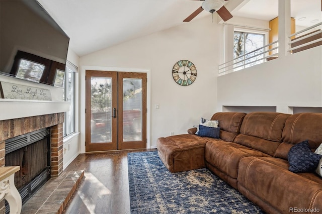 living area featuring wood finished floors, a ceiling fan, high vaulted ceiling, a fireplace, and french doors