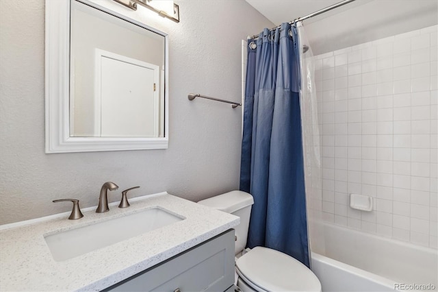 bathroom featuring toilet, vanity, and a textured wall